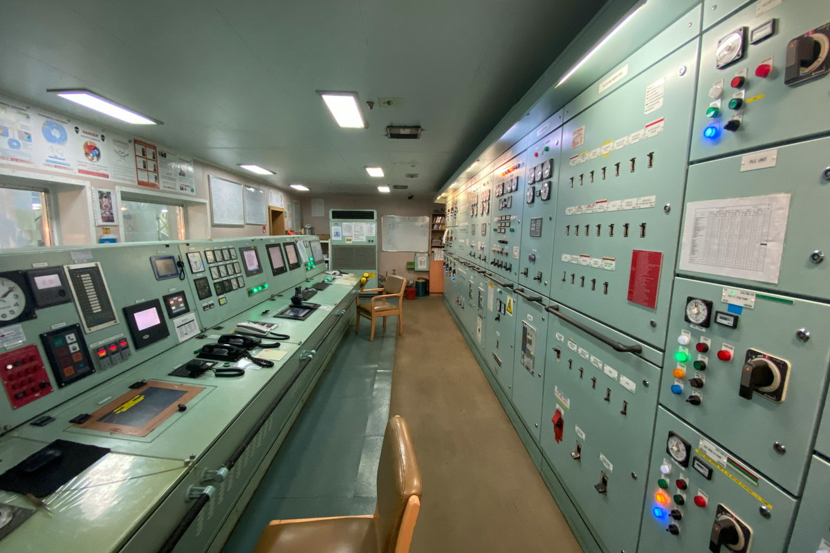 A plant control room lined with switchboard panels, indicator lamps and selector switches.